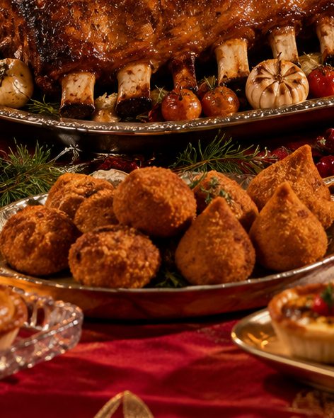 Coxinhas douradas servidas em travessa na mesa de Natal