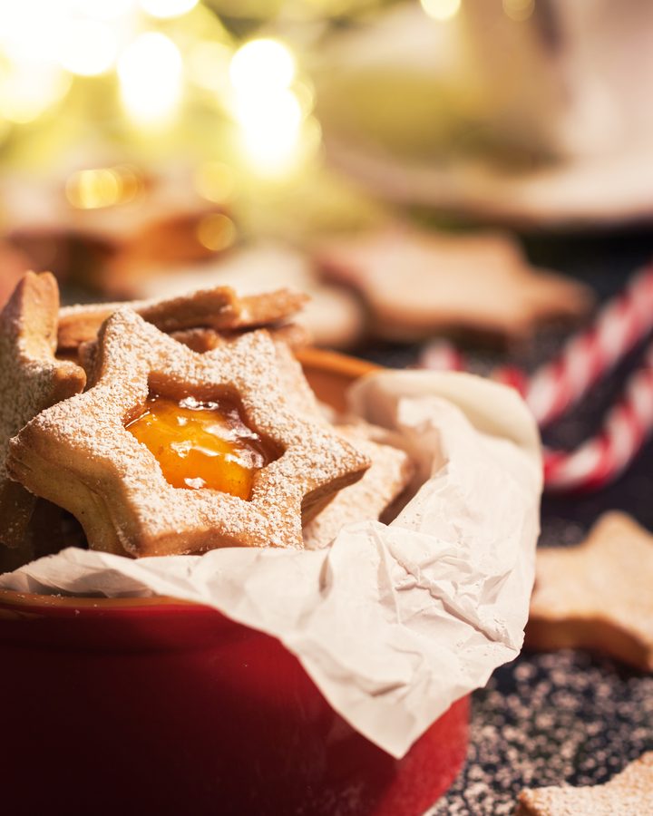 Biscoitos de estrela recheados com geleia de laranja e polvilhados com açúcar de confeiteiro
